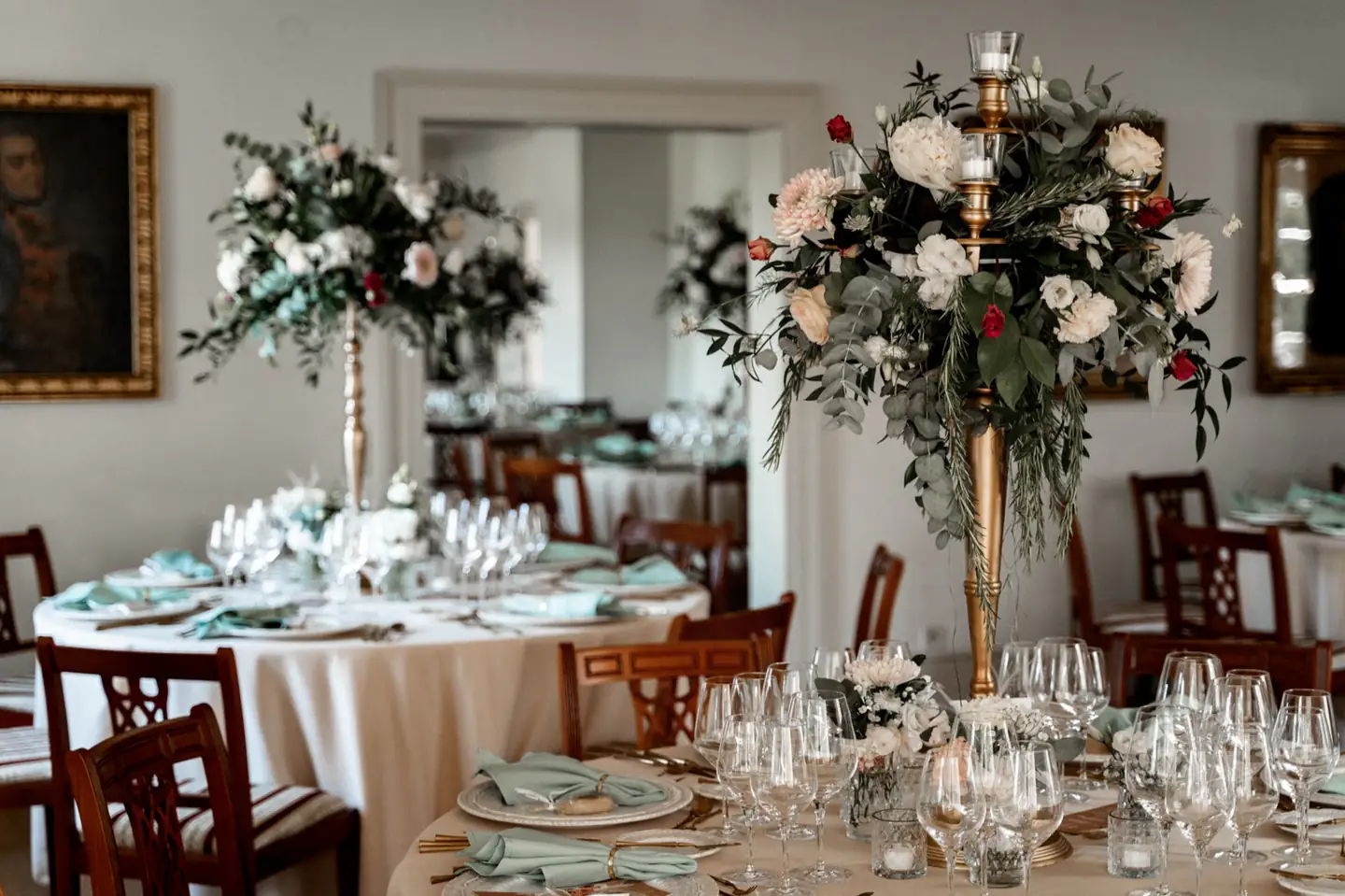 Gedeckte Hochzeitstafel mit Blumengestecken im Festsaal